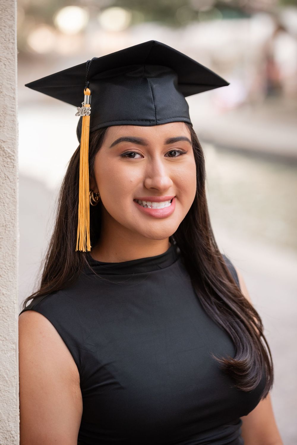Dallas senior photo of stylish graduate in black dress smiling with cap, Class of 2026