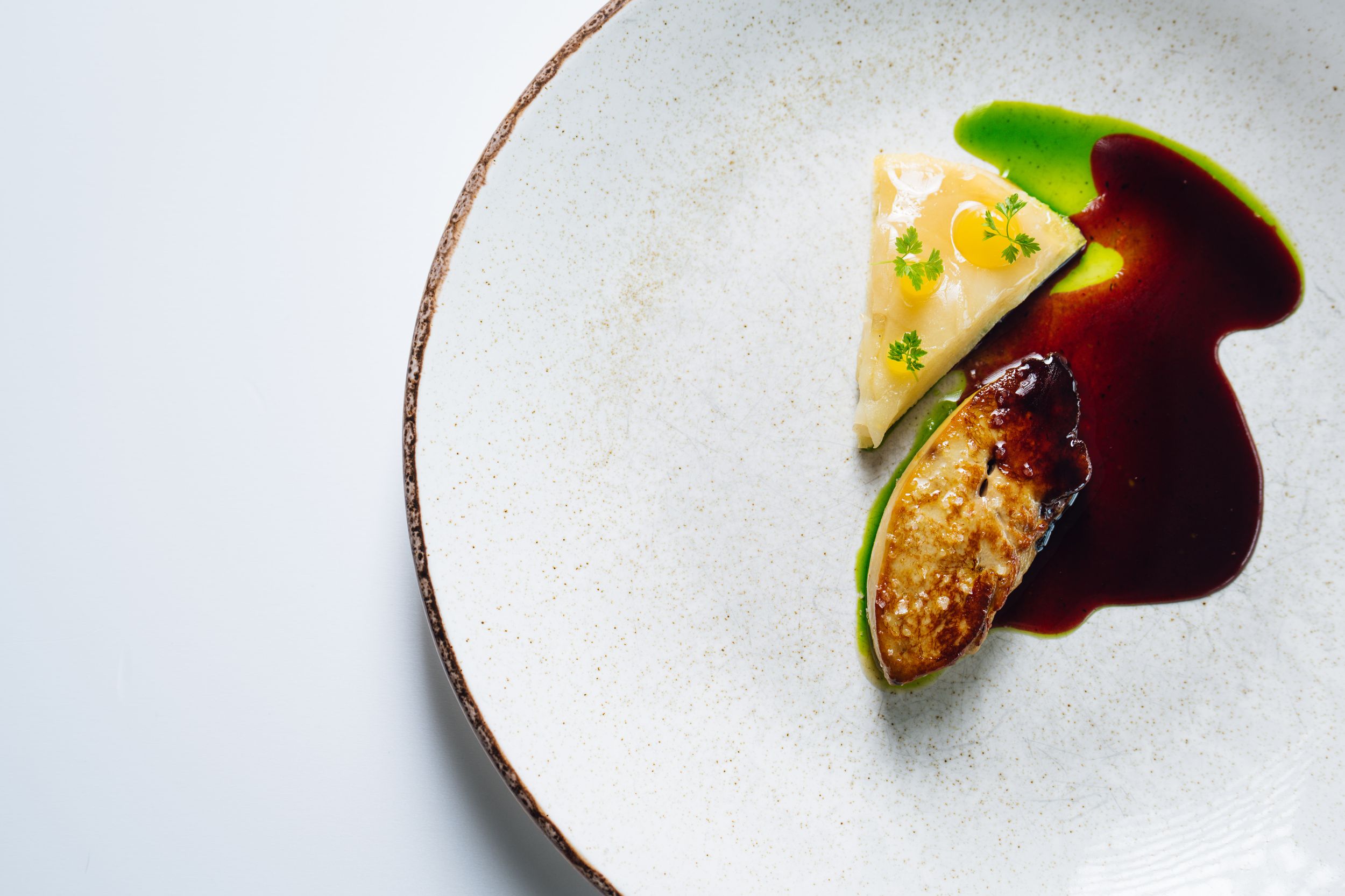Elegant plated dishes showcasing modern fine dining presentation on white plates with minimalist garnishes.