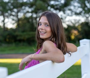 A person in a pink dress poses gracefully outdoors during golden hour lighting.