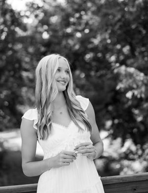 A series of candid black and white photos showing joyful expressions while sitting on a wooden bench outdoors.