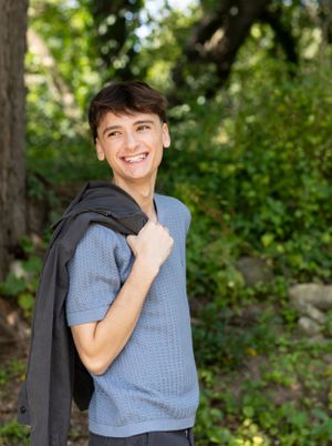 Casual outdoor portrait in a wooded setting with natural lighting.