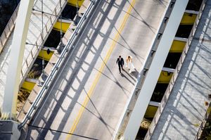 Aerial view of multiple yellow stripes painted on an asphalt road surface with curvy geometric patterns.