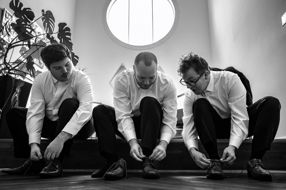 A black and white sequence of photos showing people stretching and exercising on a floor near a white wall.