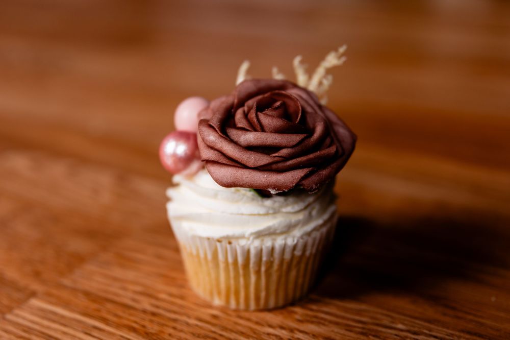 Close-up of chocolate frosted cupcakes arranged on a wooden surface.