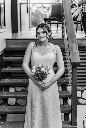 A black and white portrait series showing someone in a lace wedding dress holding a bouquet.