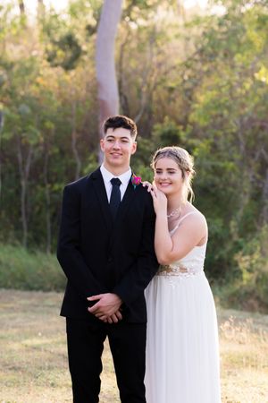 A couple shares candid moments in their wedding attire during an outdoor photo session.