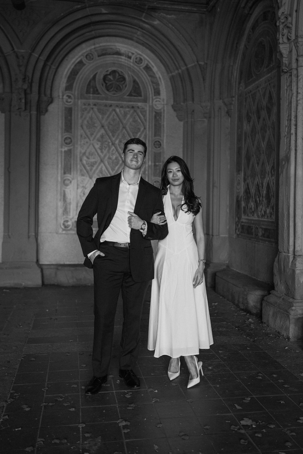 Romantic black and white photos in an ornate Gothic hallway with arched ceilings.