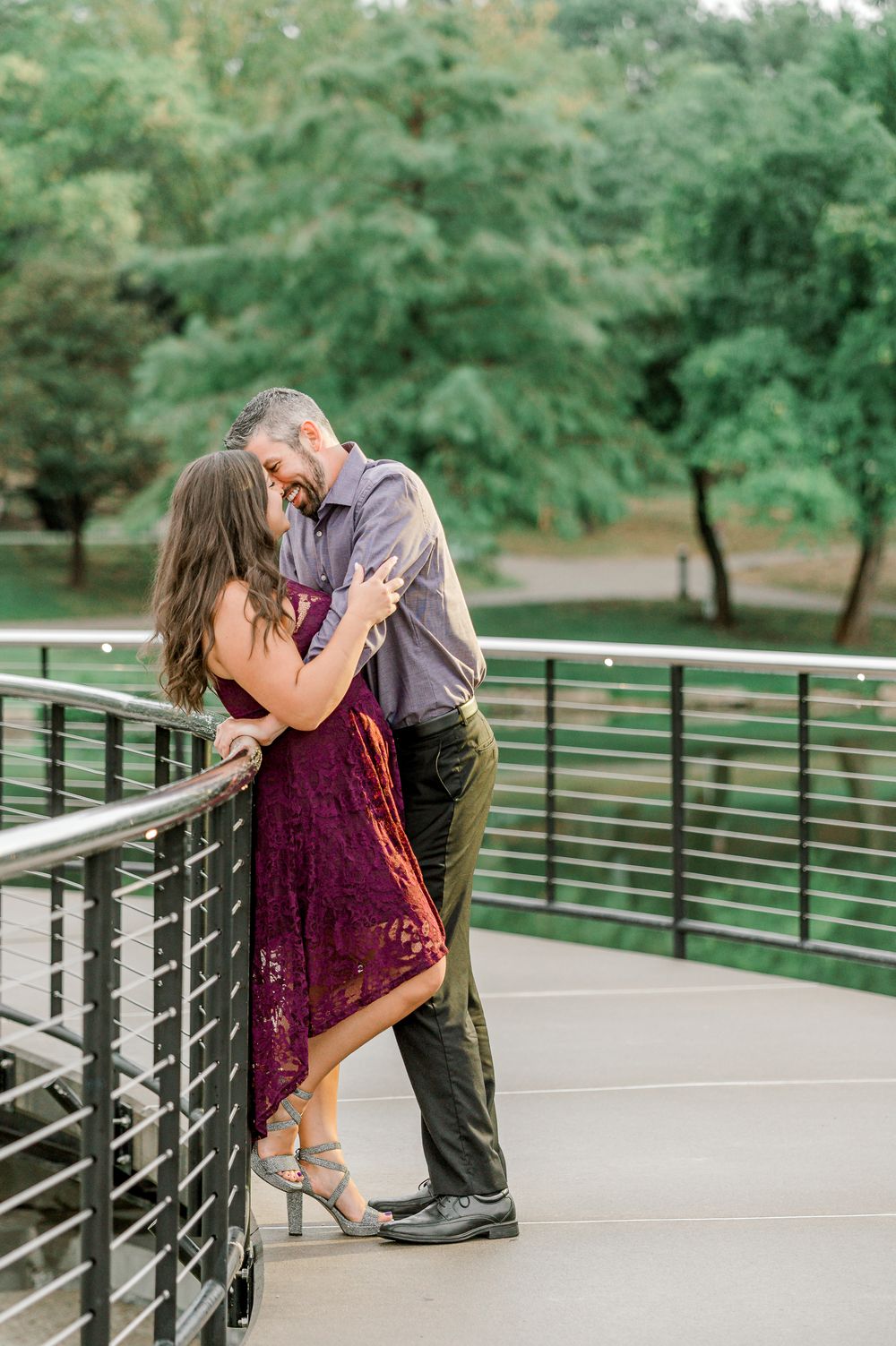 Romantic couple sharing an intimate moment on a modern bridge walkway by Stephanie Coulter Photography