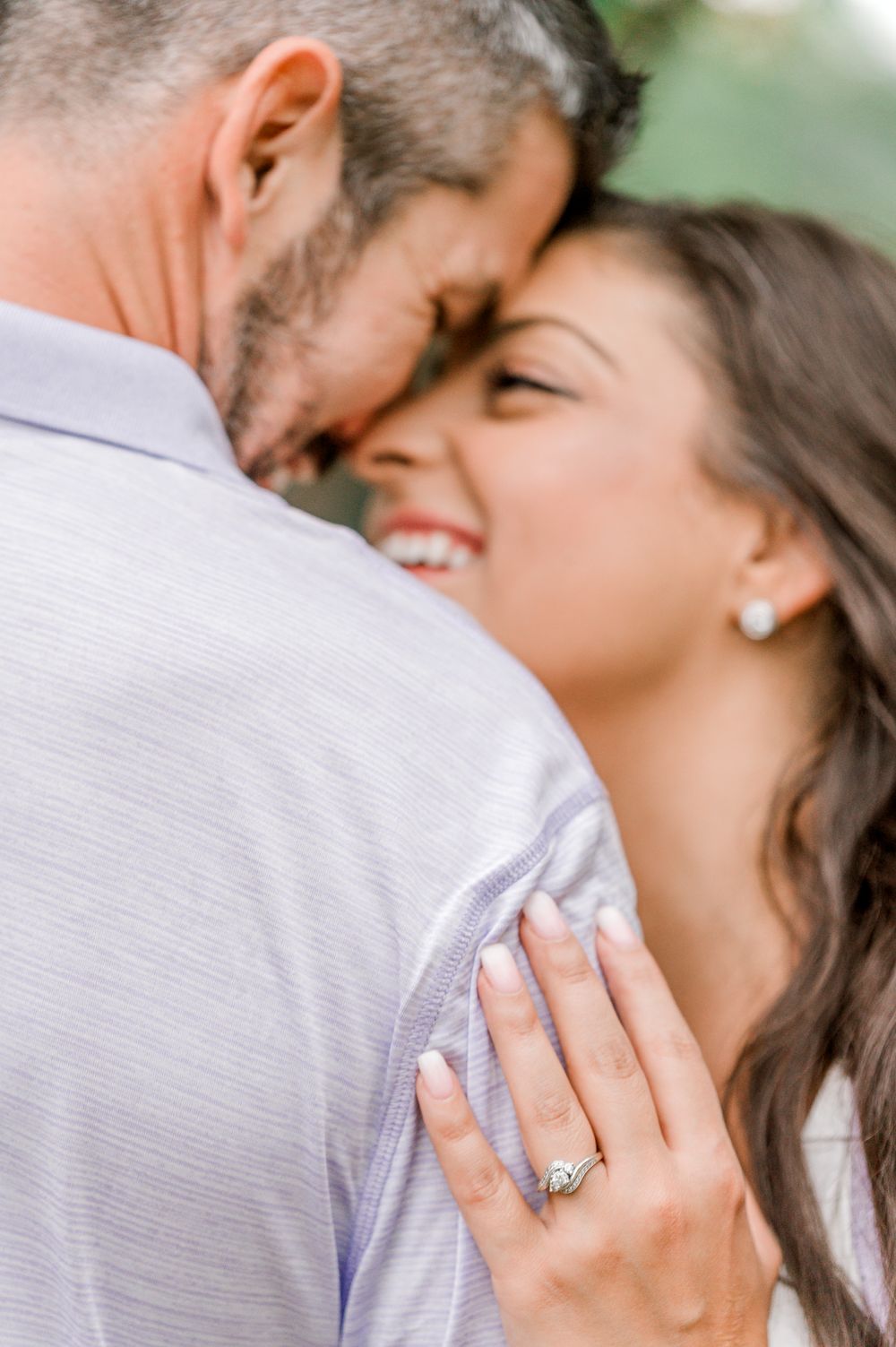 Close-up engagement photo showing diamond ring and intimate moment between couple by Stephanie Coulter Photography