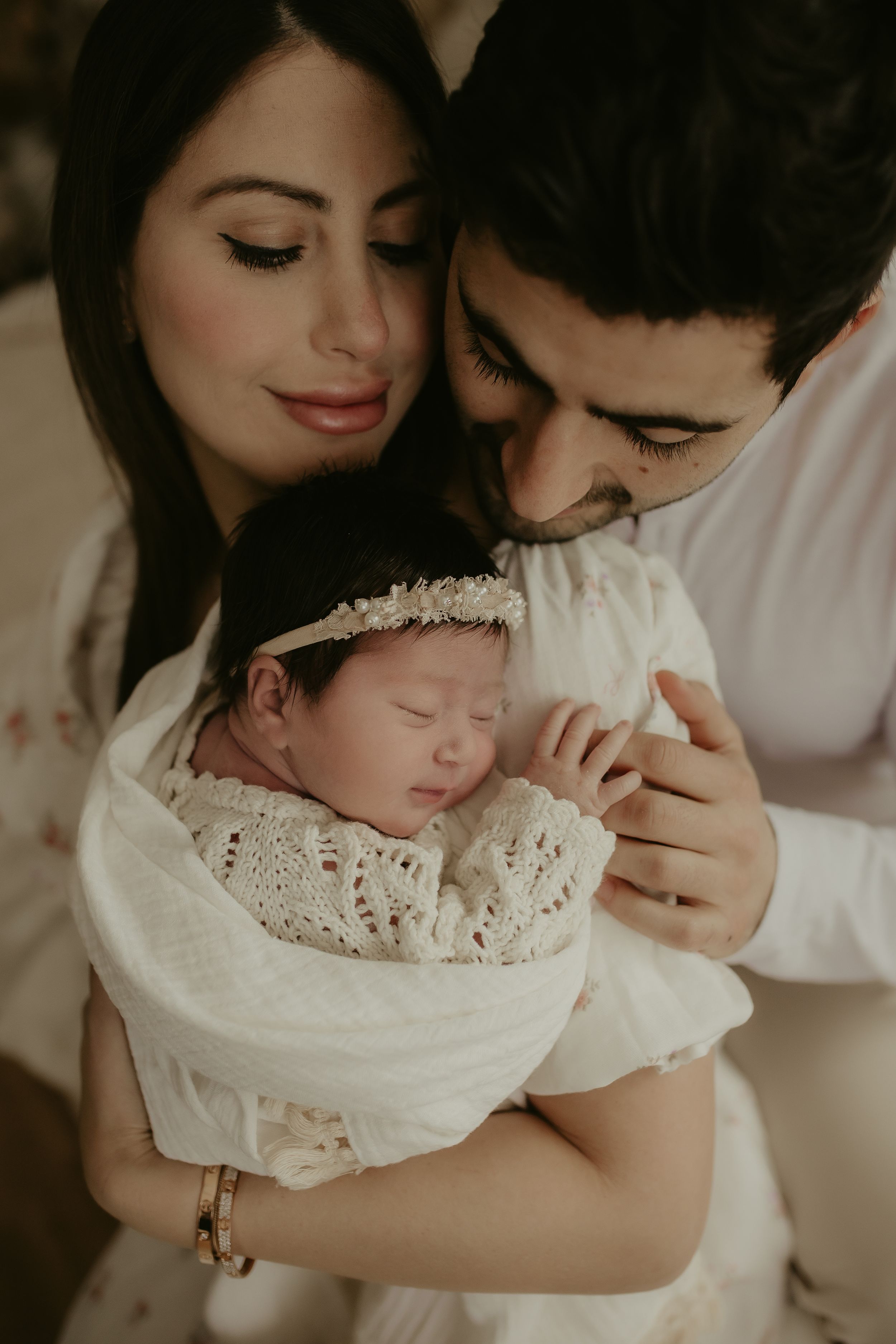A tender moment captured in white tones as a parent and child share loving embraces in multiple connected photos.