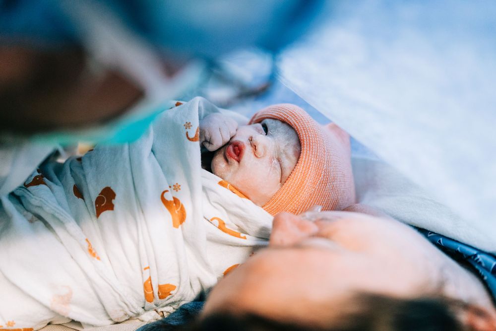 Newborn baby placed on moms chest right after delivery in the operating room, Santa Maria, CA