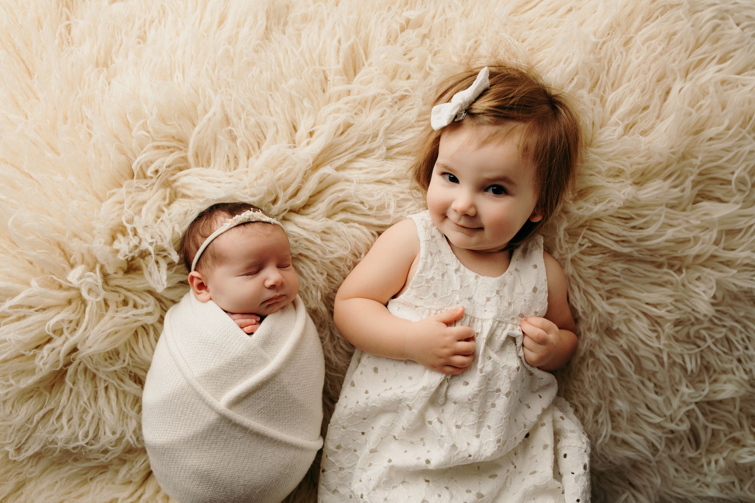 Newborn photography series on soft white fluffy rug showing peaceful sleeping poses.