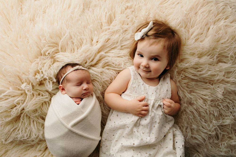 Newborn photography series on soft white fluffy rug showing peaceful sleeping poses.