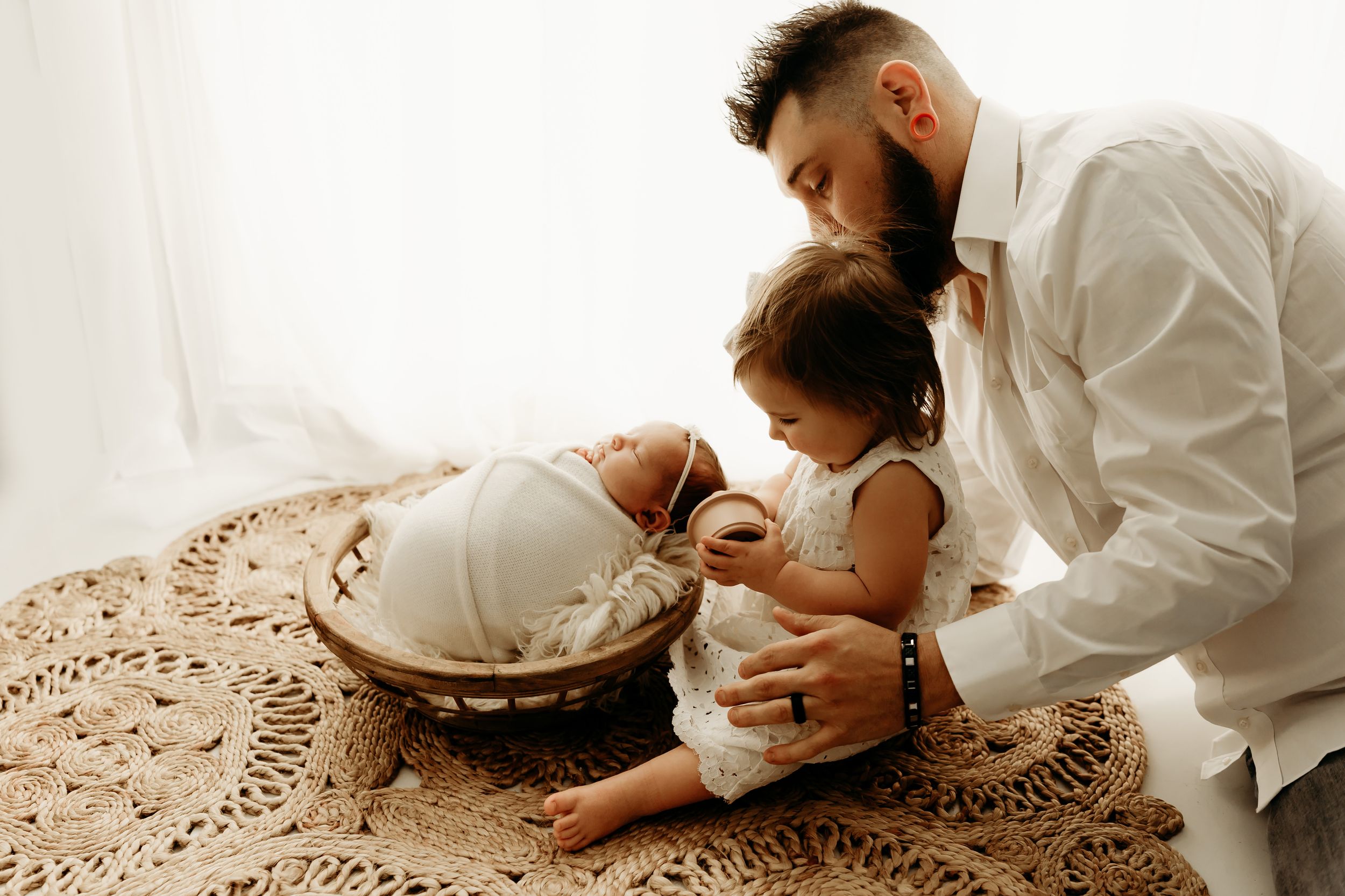 A series of tender moments between a couple in white clothing sitting on a textured rug.