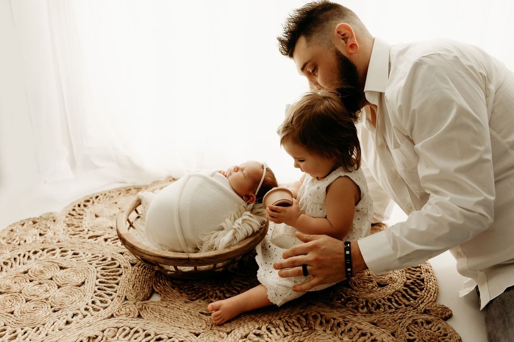 A series of tender moments between a couple in white clothing sitting on a textured rug.