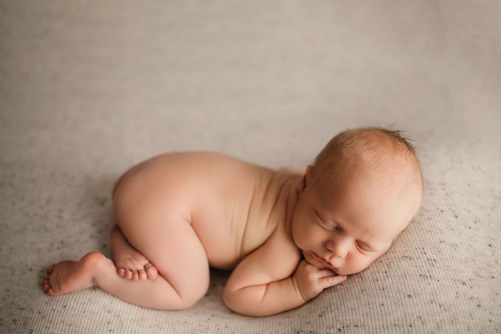 Artistic black and white newborn photography series showing peaceful sleeping poses.