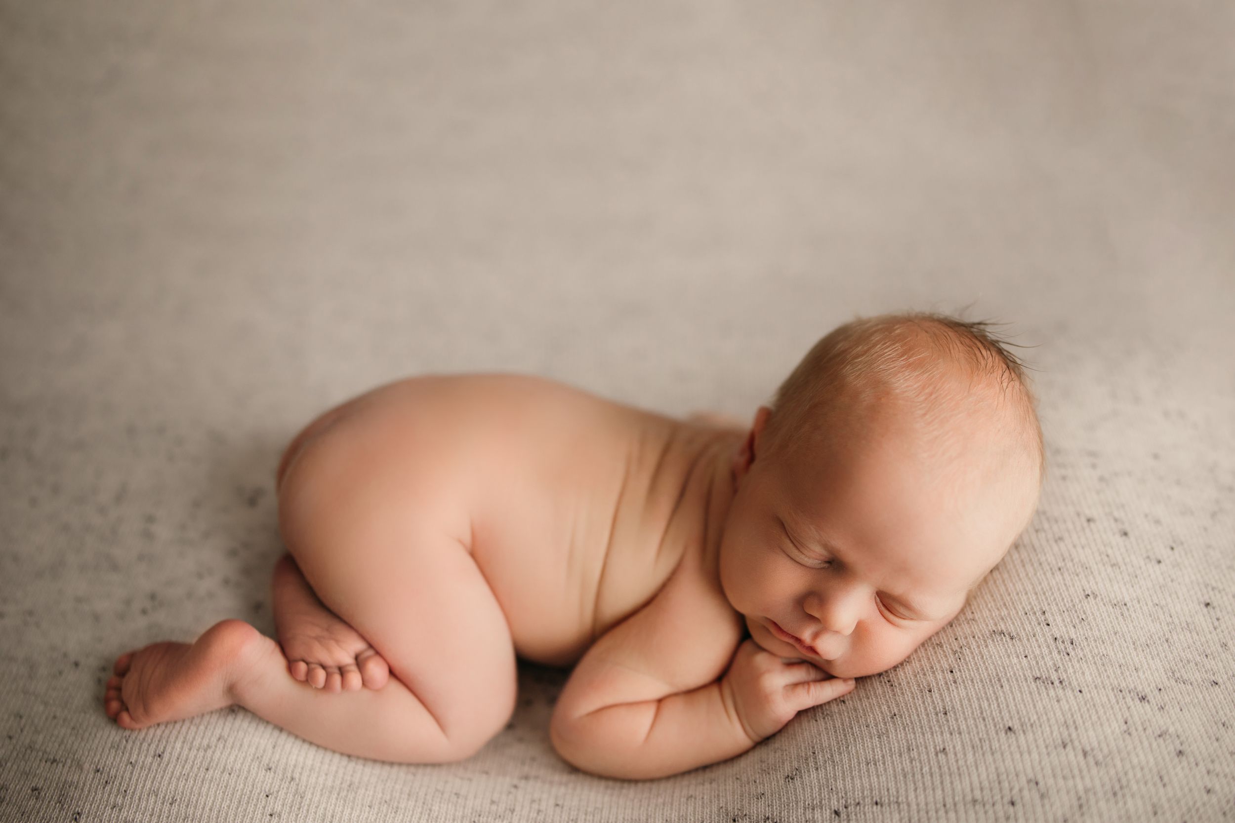 Artistic black and white newborn photography series showing peaceful sleeping poses.