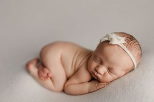 Artistic black and white portrait of sleeping newborn baby on textured background.