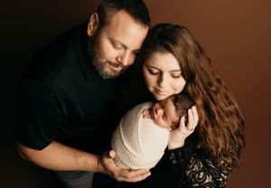 A romantic couple embraces intimately in a series of moody dark portraits with warm lighting and tender expressions.
