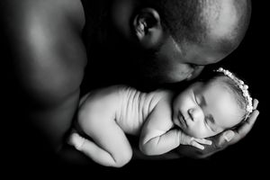 A series of black and white photos showing intimate close-up portraits of a parent and child in tender moments.
