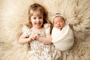A series of six connected images showing a baby in white lace clothing laying on a cream-colored fur rug.