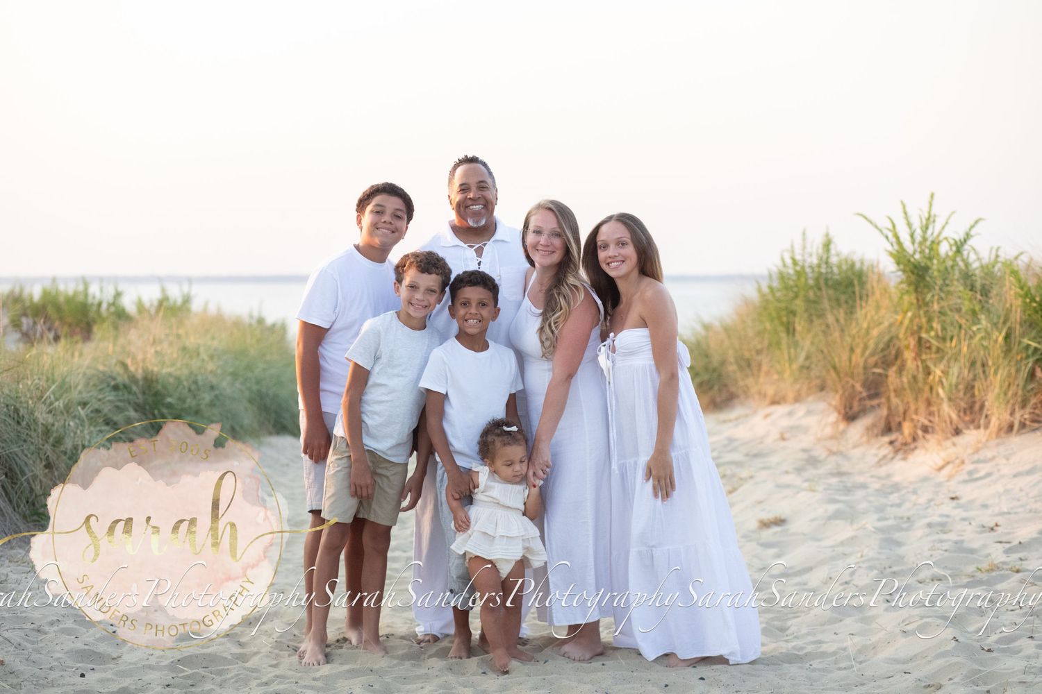 Family at the beach posing at beach entrance during sunset