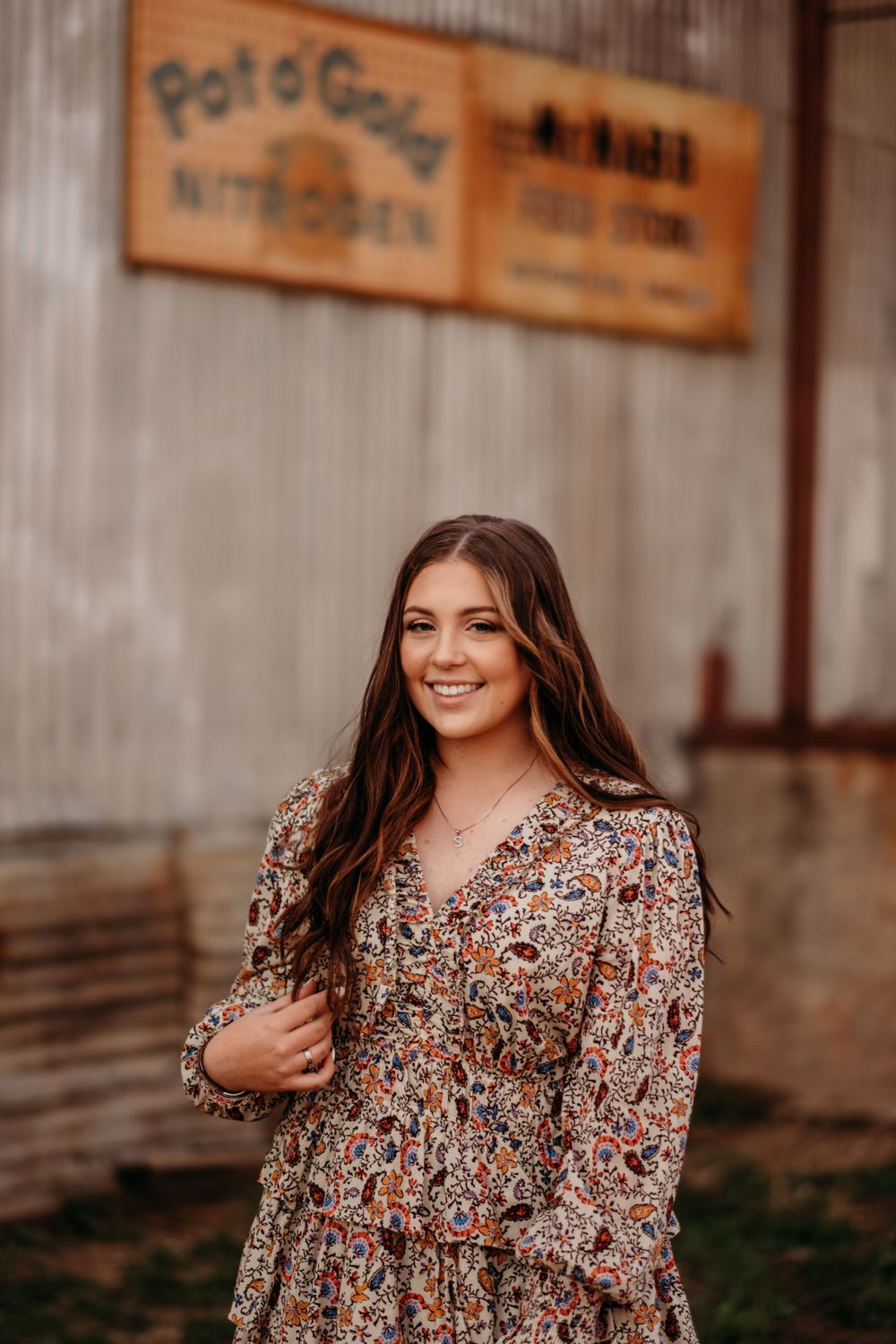 A series of fashion portraits in a floral print dress against a rustic wooden wall backdrop.