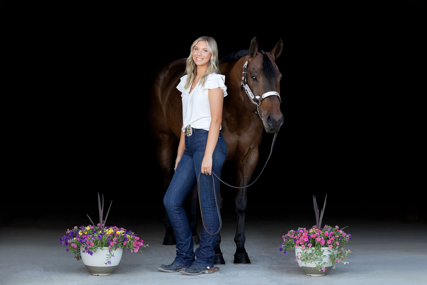 girl with bay horse on black background
