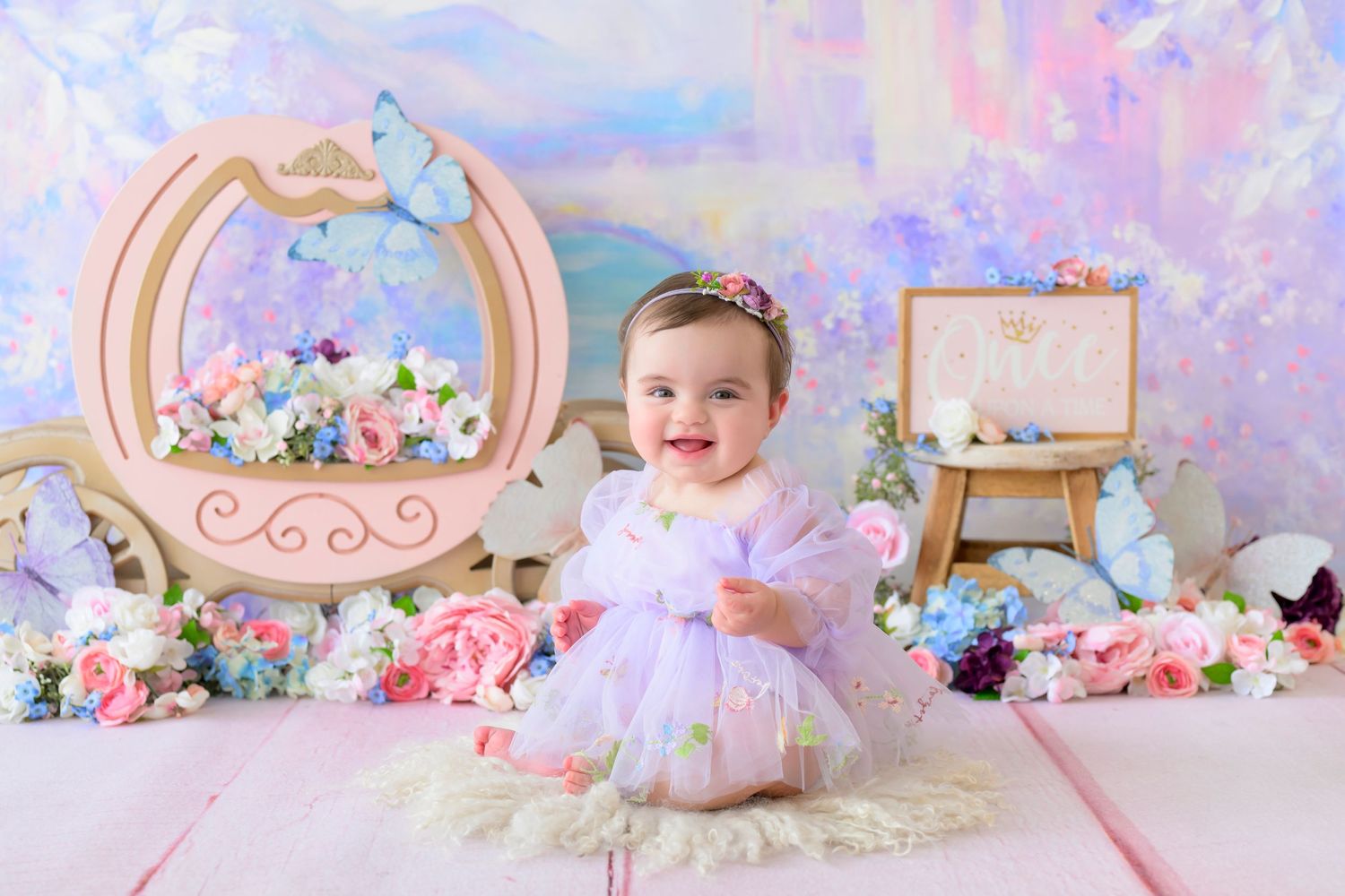 smiling little girl in purple dress with cinderella carriage and butterflies