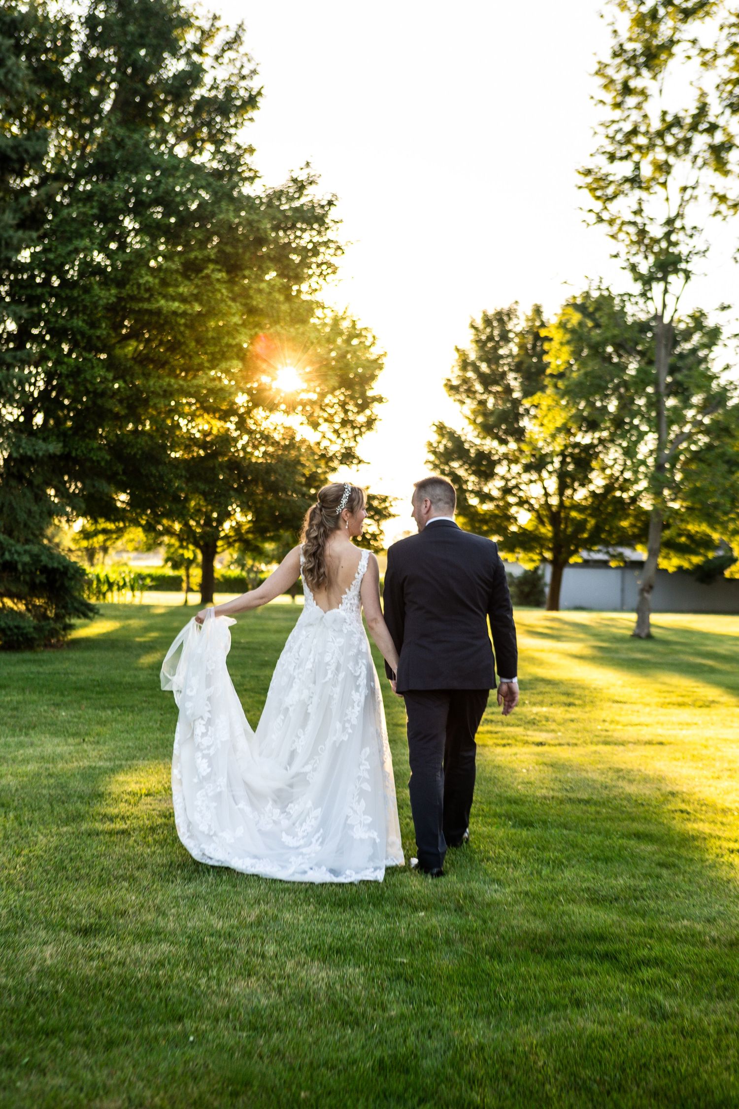 Romantic sunset moment between newlyweds sharing joyful embrace outdoors.