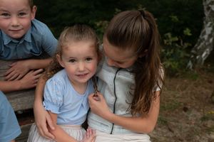 Four candid outdoor photos show people in light blue clothing spending time together in a natural setting.