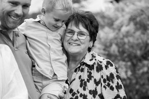 Black and white collage of candid family photos showing joyful moments and laughter in an outdoor setting.