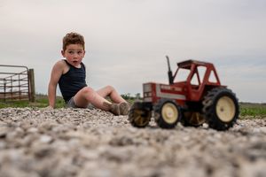 A collection of photos showing a toy tractor on gravel from different angles and perspectives.