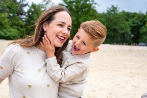 Playful interactions and genuine laughter during a beach photoshoot.