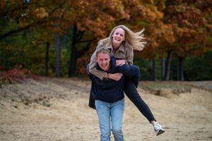 Playful autumn photoshoot with falling leaves and natural interactions.