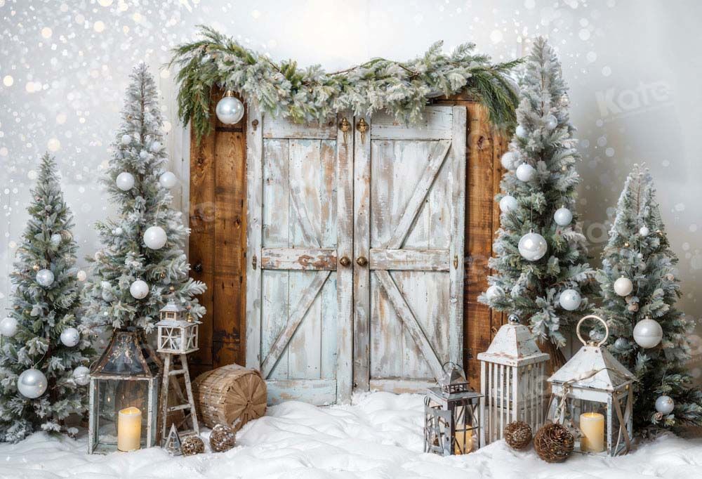 Rustic winter backdrop with wooden doors, evergreens, and lanterns in snow setting.