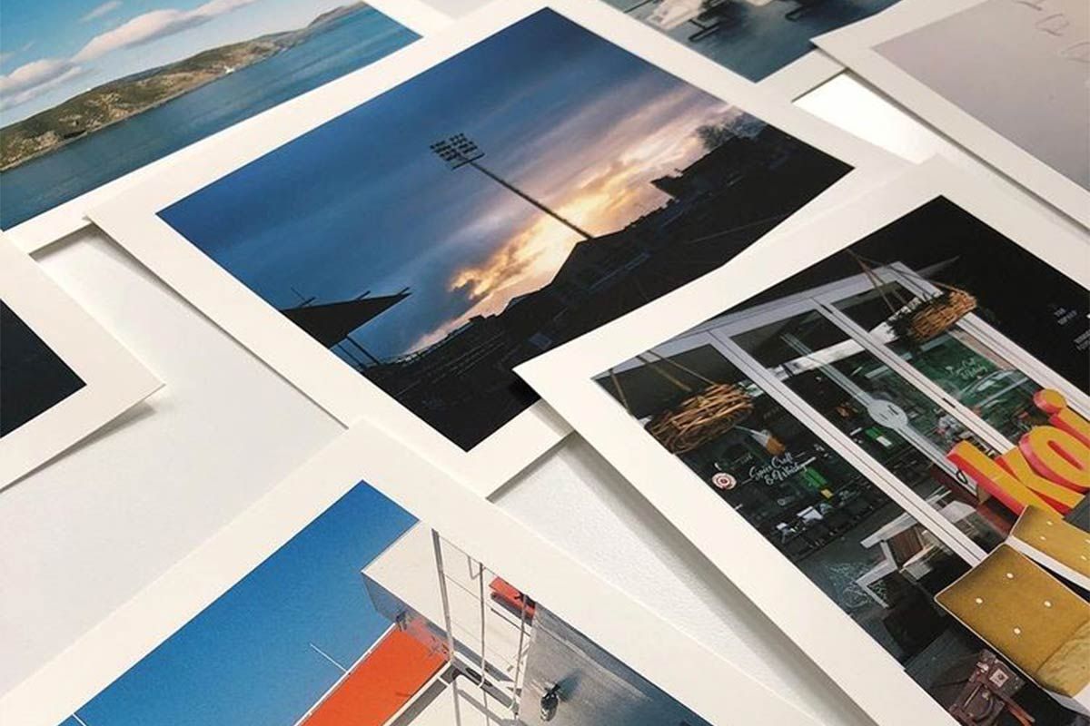 Collection of polaroid-style photographs scattered on a surface showing landscapes and memories.