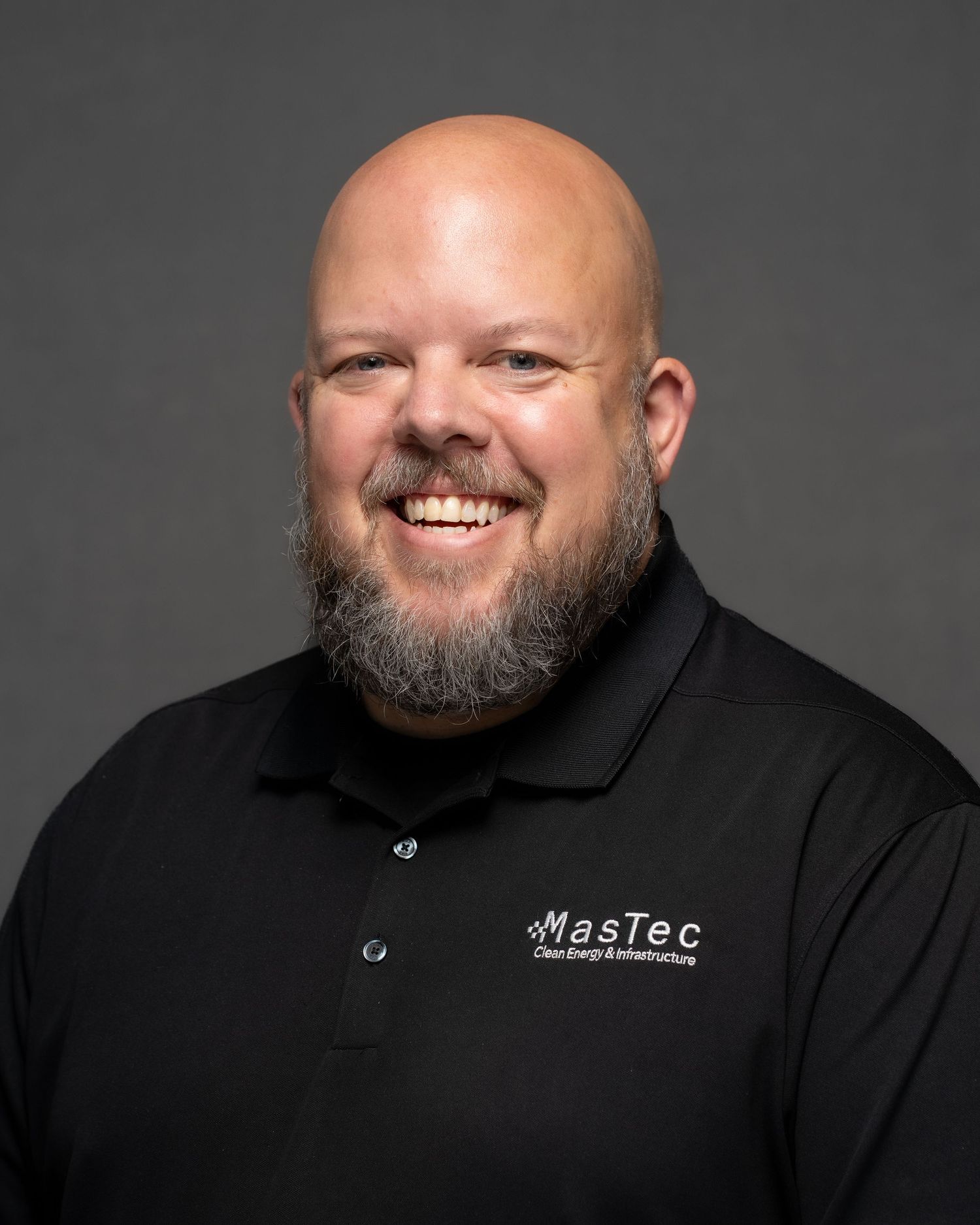 Smiling man in white a polo shirt posing for a professional headshot