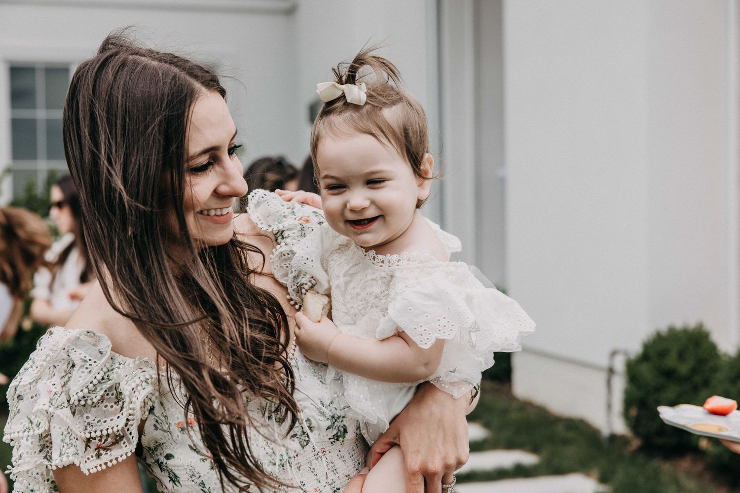 A tender moment captured between parent and child at an outdoor celebration.