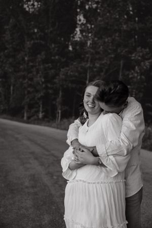 Romantic couple sharing intimate moments and laughter in an outdoor setting.