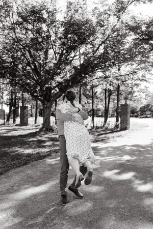 Playful dance sequence in a tree-lined park setting.