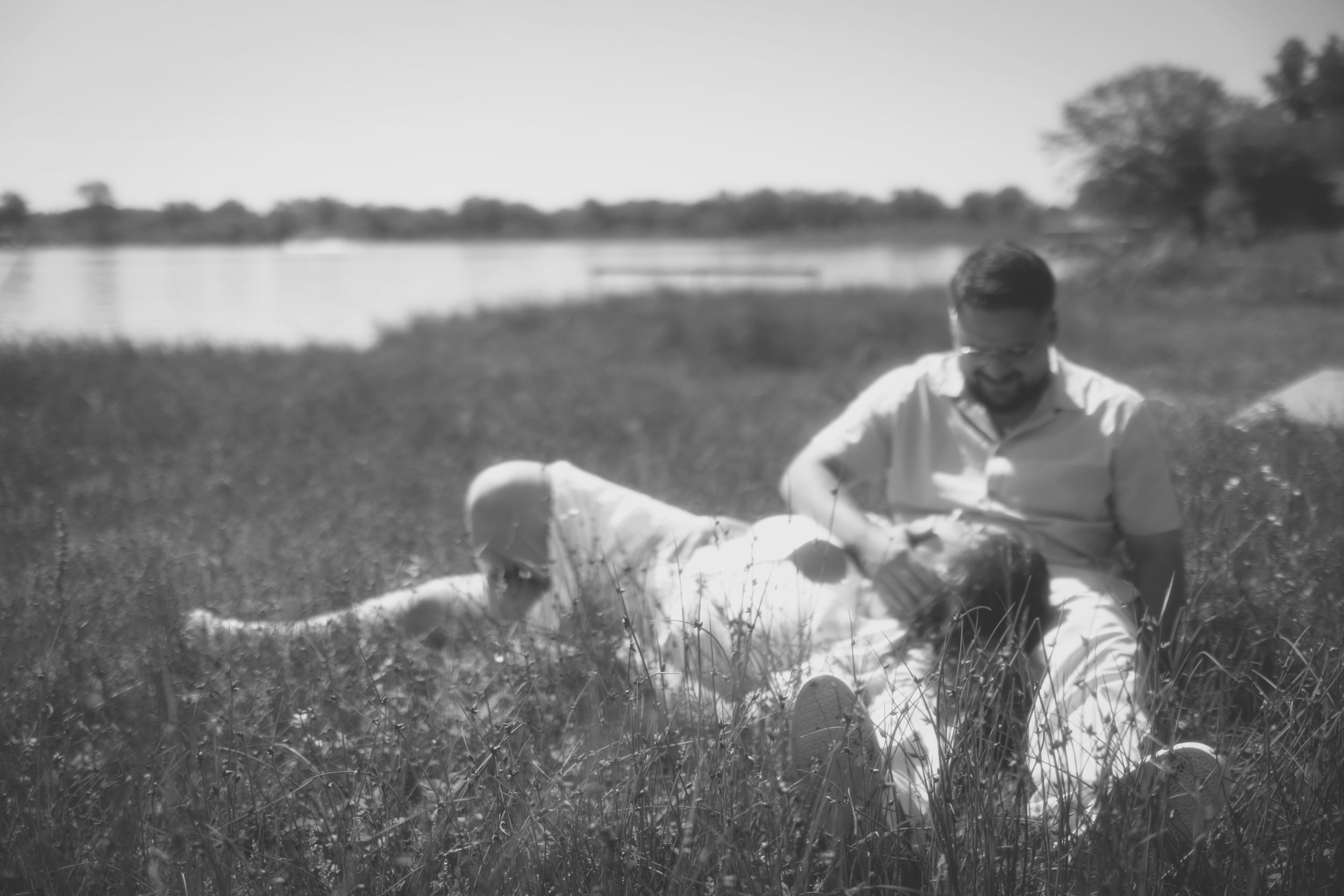 A person and dog relax together in a sunny meadow filled with wildflowers on a summer afternoon.