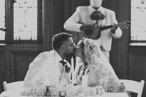 A black and white photo shows a couple sharing a joyful moment during their wedding celebration.