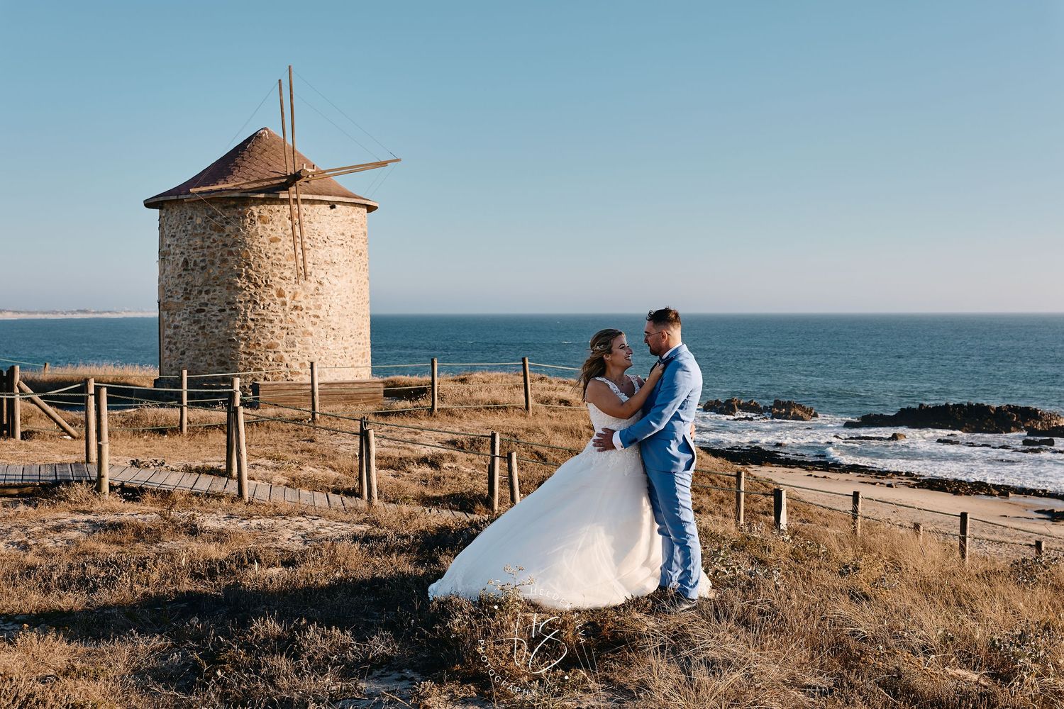 Noivos na sua sessão de Pós Casamento na Praia da Apulia, com um moinho no fundo