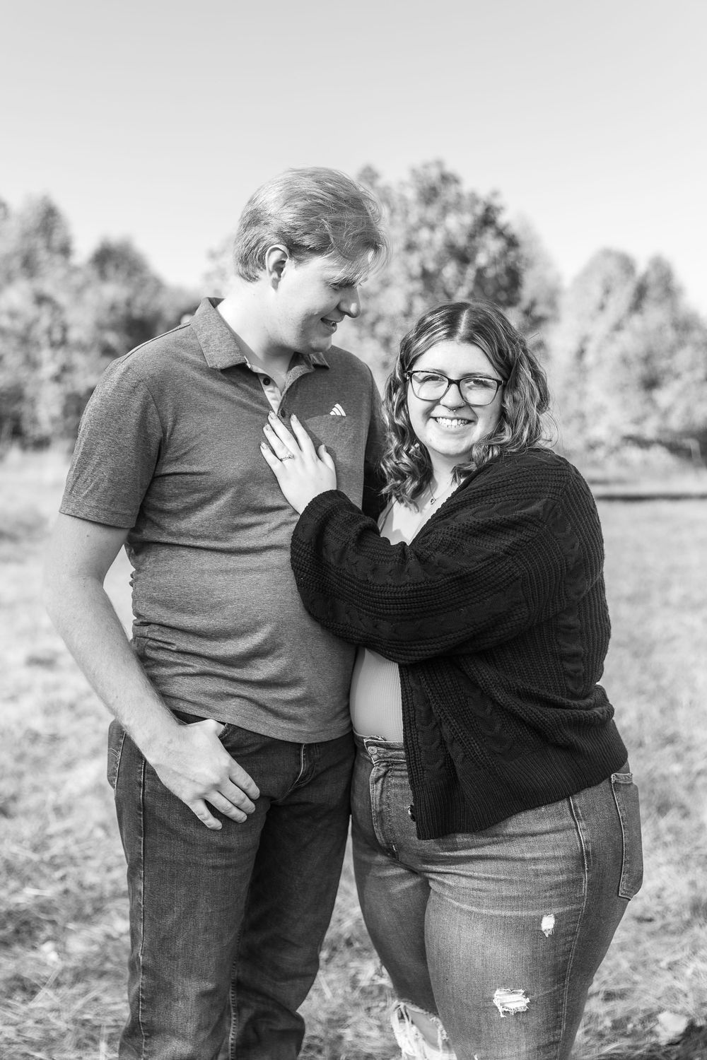 A happy couple poses together in black and white during their engagement photo session.