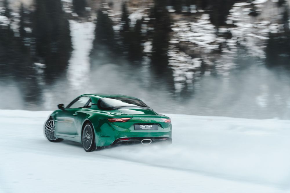 Green sports car driving through a snow-covered forest road in winter — luxury automotive brand photography — Paul Brechu
