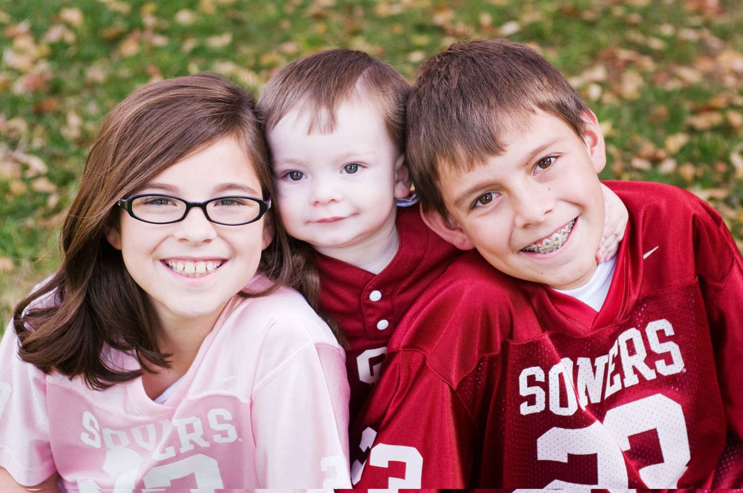 3 siblings smiling at the camera
