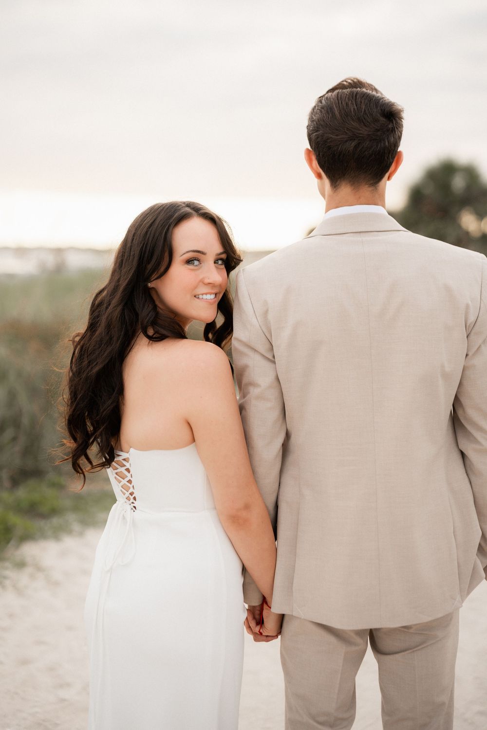 Couple embracing on the dunes in soft evening light