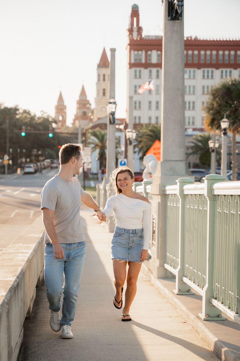 Engaged couple walking through palms at sunset