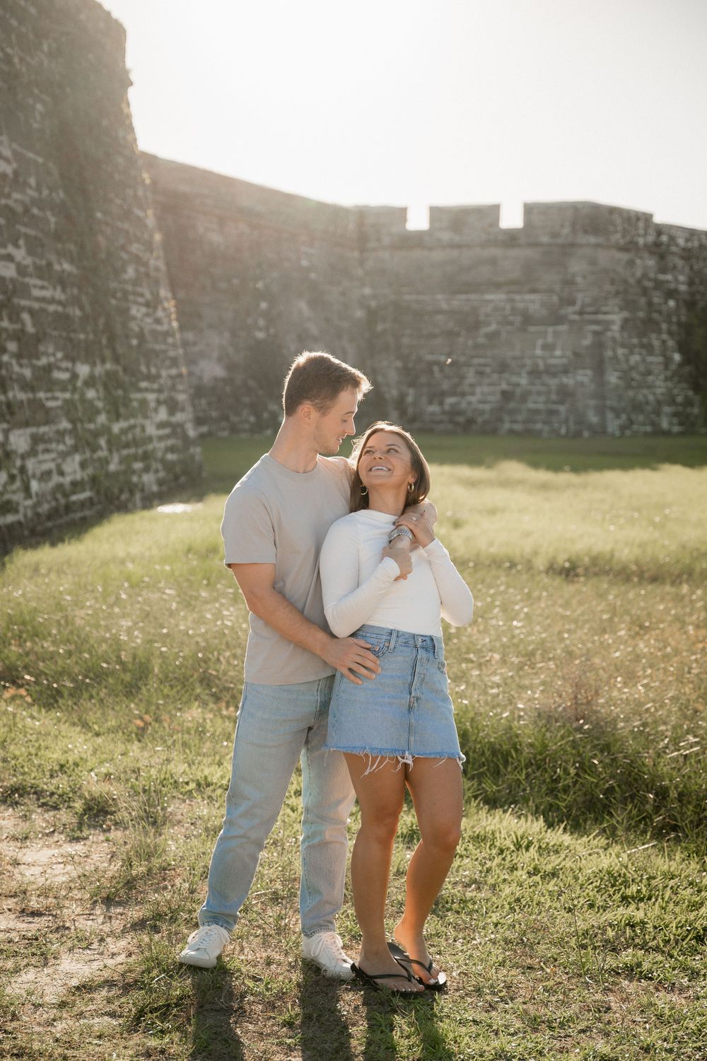 Couple embracing on the beach during a golden hour engagement session